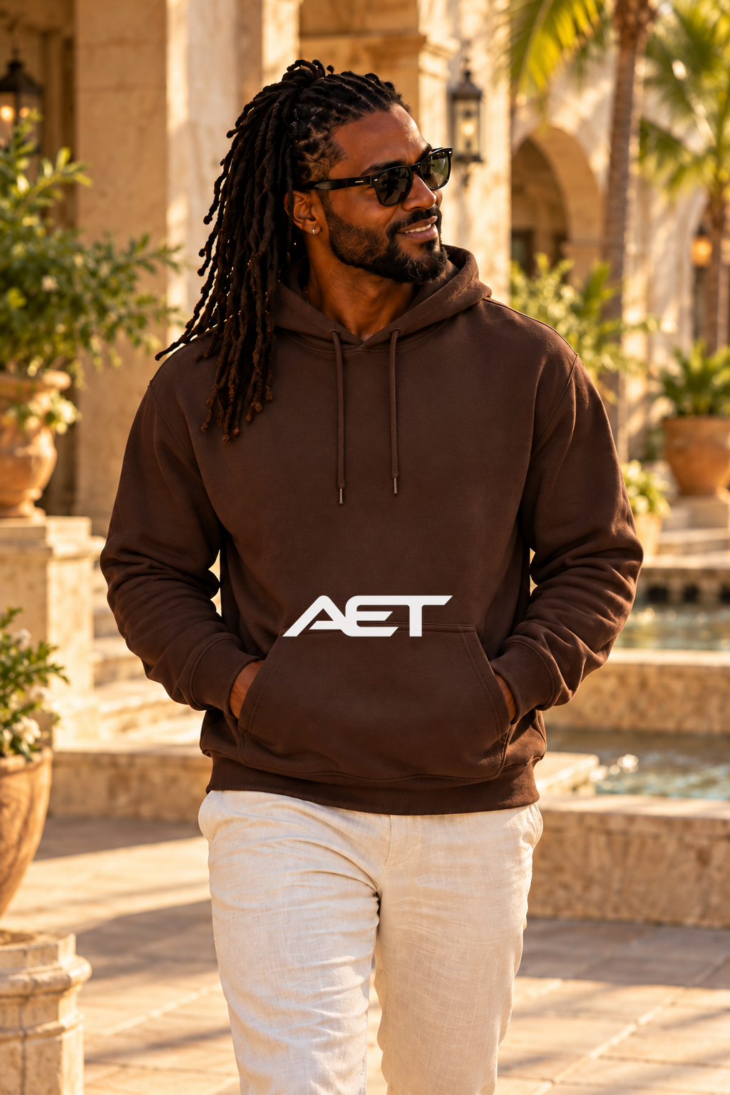 Kael wearing the AET Core Hoodie in Dark Chocolate, featuring the connected AET wordmark.