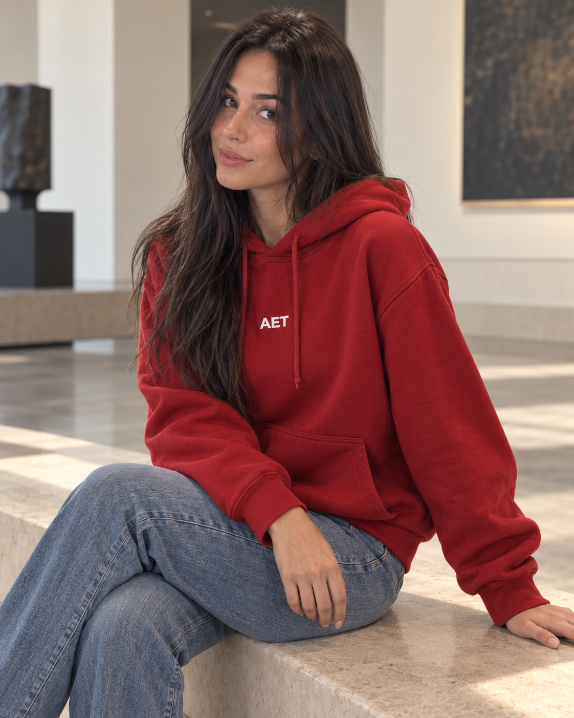 Mila wearing the AET Core Hoodie in a modern gallery