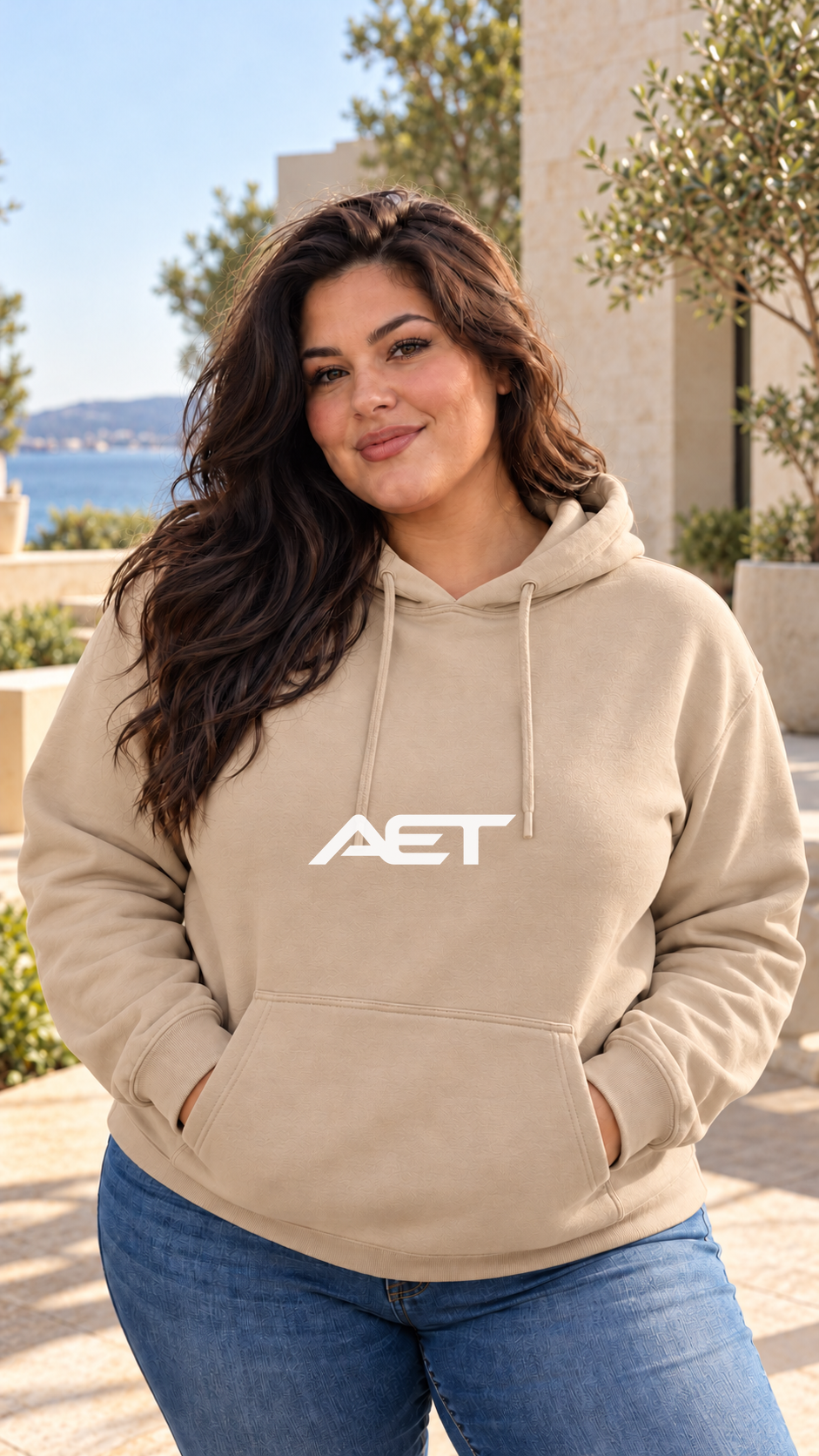 Valentina wearing the AET Core Hoodie in Sand, featuring the connected AET wordmark.